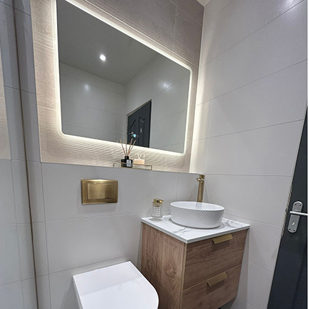 1000x700mm bluetooth led bathroom mirror hung landscape above sink and toilet in bathroom with gold features