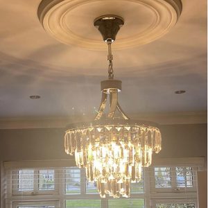 A 5 light Crystal Tiered Chandelier hanging in a living room
