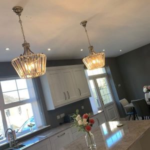 crystal chandeliers illuminated above a kitchen island