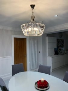Large Crystal Glass Chandelier Hanging Above Round Dinner Table